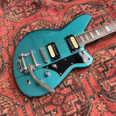 A 2013 Reverend Warhawk offset body electric guitar in Deep Sea Blue Metallic with Bigsby and 2 Humbucker type Pickups. All original. Unmarked condition with extremely light playwear. Rosewood fingerboard. No tarnishing or marking to frets. No evidence of marking or scratches to body or neck.
