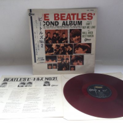 A rare and early Japanese pressing of The Beatles 'Second Album' on red vinyl complete with obi strip and insert, includes 'Gan't Buy Me Love' and 'Do Tou Want To Know A Secret' spelling errors on label. Vinyl Ex.
