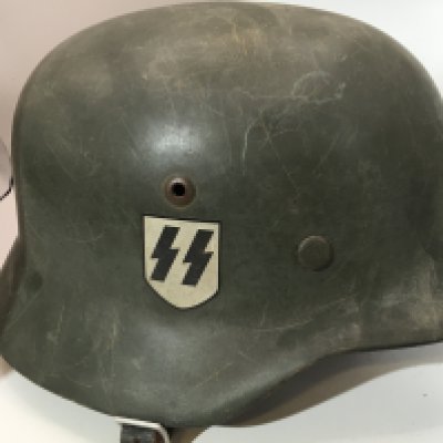 A German Third Reich steel helmet M35 pattern with double sided decal SS and swastika green finish The inner stamps Q66 and 192 with leather liner stamped 58 very good condition.
