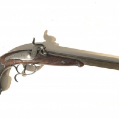 An early 19th century Percussion target or Duelling pistol the half length stock and grip with carved stylised acanthus leaf and silver mounted end to the grip octagonal barrel very nice condition no makers marks or inscriptions. Length 40cm