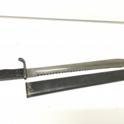 A German I world war bayonet the 98/05S pattern with wooden grip with a sawback edge blade the blade stamped with a Berlin maker metal scabbard. Length 51cm