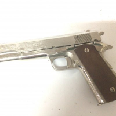 A Japanese made Chrome finish replica, non firing pistol.An American Army colt M191.