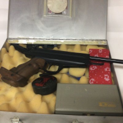 A German target Air gun model 80 .177 caliber and with a carved wood grip maker Feinwerkbau sold in an aluminium case with some accessories.