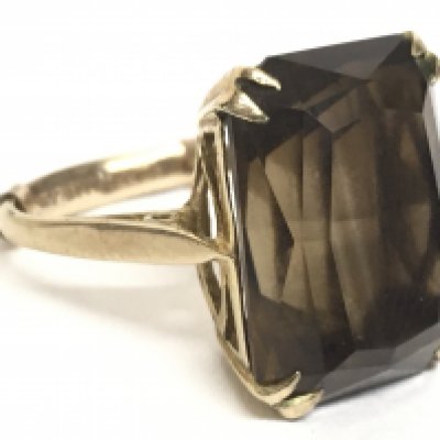 A 9 carat yellow gold ring set with a smoky citrine stone. 6g. Postage category A