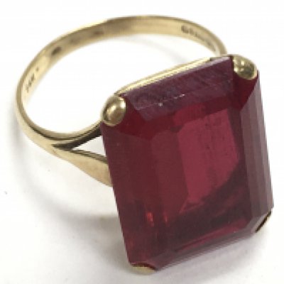 A 9 carat gold ring mounted with a large red garnet stone, 5.8g. size N. Postage category A