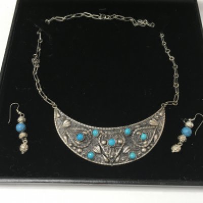 A silver and turquoise set with a necklace and pair of earrings.