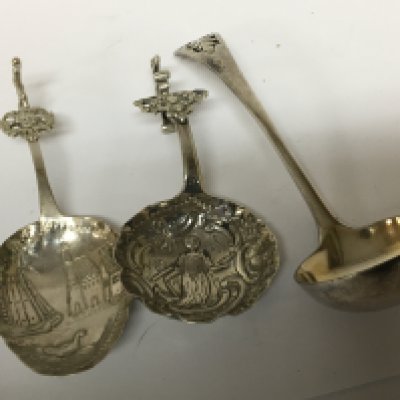 Two Continental silver spoons repousse decorated with figures and buildings and an unmarked sugar spoon. (3) NO RESERVE