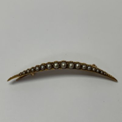 A unmarked edwardian gold crescent moon brooch set with seed pearls. (A)