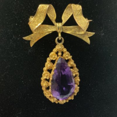 An Edwardian gold and amethyst drop brooch. (A)