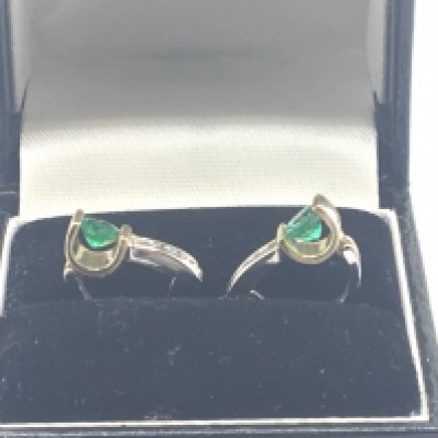 A pair of quality 14carat gold earrings of modern design white and yellow gold set with an emerald with diamonds. Weight 3g approximately.