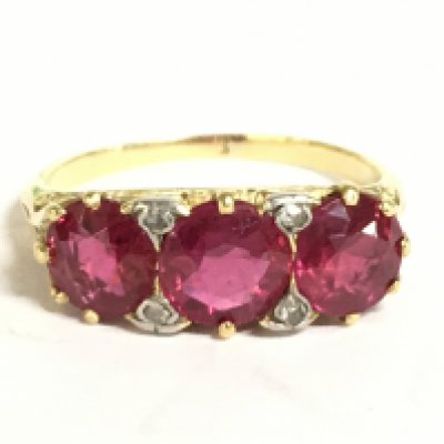 An 18ct gold and diamond shard 3 red stone ring, 3.8g. Size M Postage category A