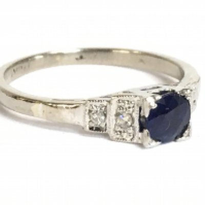 An Art Deco diamond and blue sapphire set platinum ring, size J, 2g. Postage category a