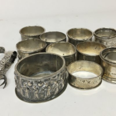 A Chinese white metal dish decorated with figures a quantity of silver napkin rings and silver sugar tongs.