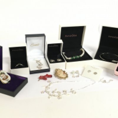 A selection of Pandora jewellery, a Tommy Steele Wade porcelain brooch, Cameo brooch, Swarovski necklace with matching earrings and a red coral pendant