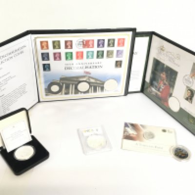 A collection of silver coins including the 50th anniversary of Decimalisation silver proof coin collection cover, The Queens Official Birthday Silver Coin Cover, Timeless First George and the Dragon 2013 20 pound fine silver coin, Britannia Elizabeth II Effigy etc. Postage category C