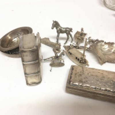 A collection of Continental silver and white metal ornaments animals and figures a tea strainer silver box miniature bible case and other items.