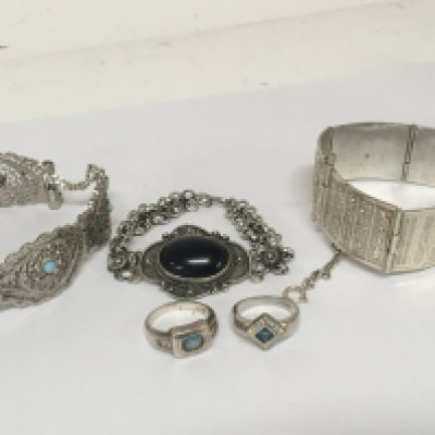 An Egyptian theme silver bracelet a filigree bracelet set with turquoise two silver rings and one other bracelet.