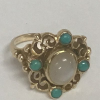 A 9carat gold ring set with turquoise and moon stone with open scroll shank. Weight 6.5g ring size R.