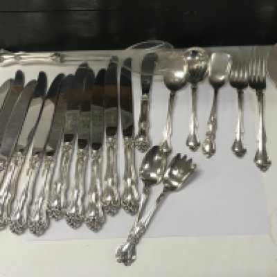 A collection of sterling cutlery including knives forks spoons serving spoons.