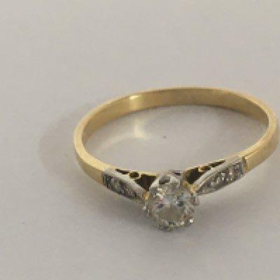 A gold ring set with an old cut solitaire diamond 0.20 of a carat approximately flanked by chip diamonds weight 2g unmarked gold. Ring size O