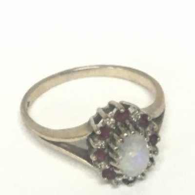 A 9carat gold ring set with an oval Opal flanked by further stones. Weight 2.4g ring size P.