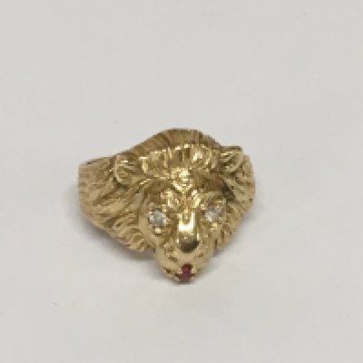 A 14carat gold ring in the form of a lions head the eyes brilliant cut diamonds and ruby mouth ring size V weight 13g