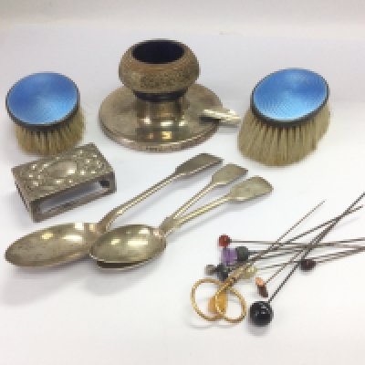 A silver candlestick, three silver spoons, enamel and silver backed brushes, stick pins etc. Shipping category B.