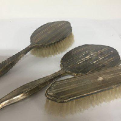 A Silver backed hand mirror and two matching brushes Birmingham hallmarks (3) 