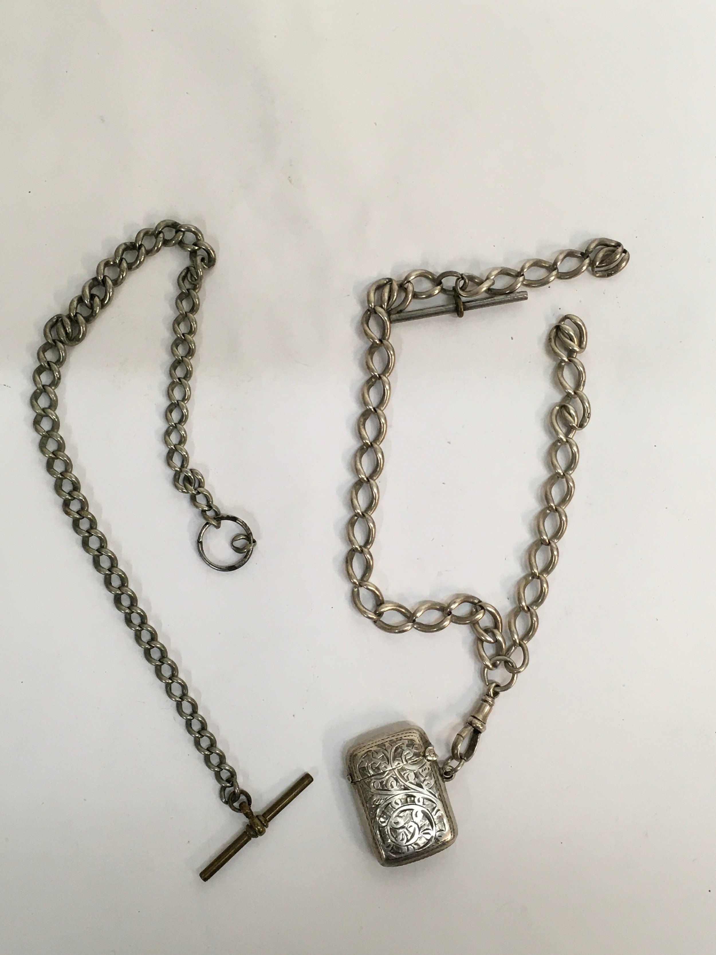 A silver vesta case on chain, plus one other white metal fob chain. Approx collective weight 68g