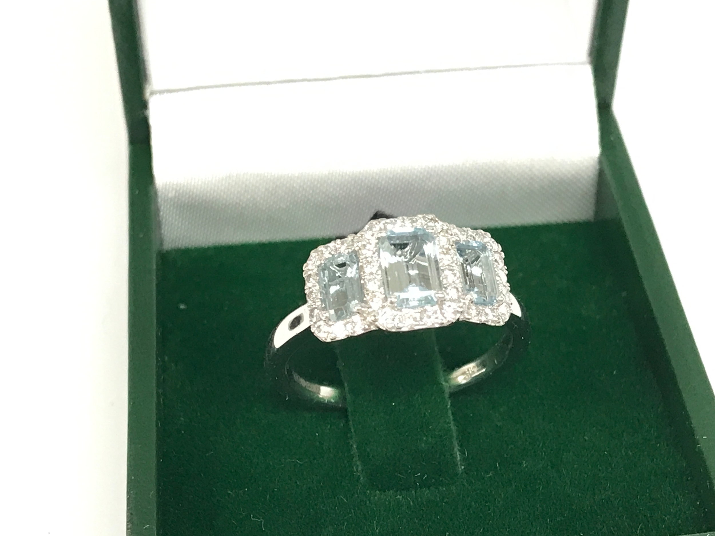 A platinum step cut aquamarine and round cut diamond trilogy ring. Aquamarine 0.98ct and diamonds 0.34ct. Size O