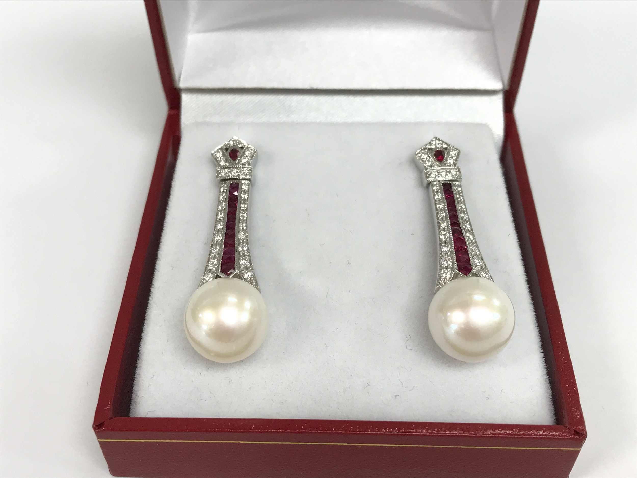 Pair of 18ct white gold art deco style drop earrings set with rubies, diamonds and cultured pearls. 1.10ct rubies and 0.53ct diamonds.