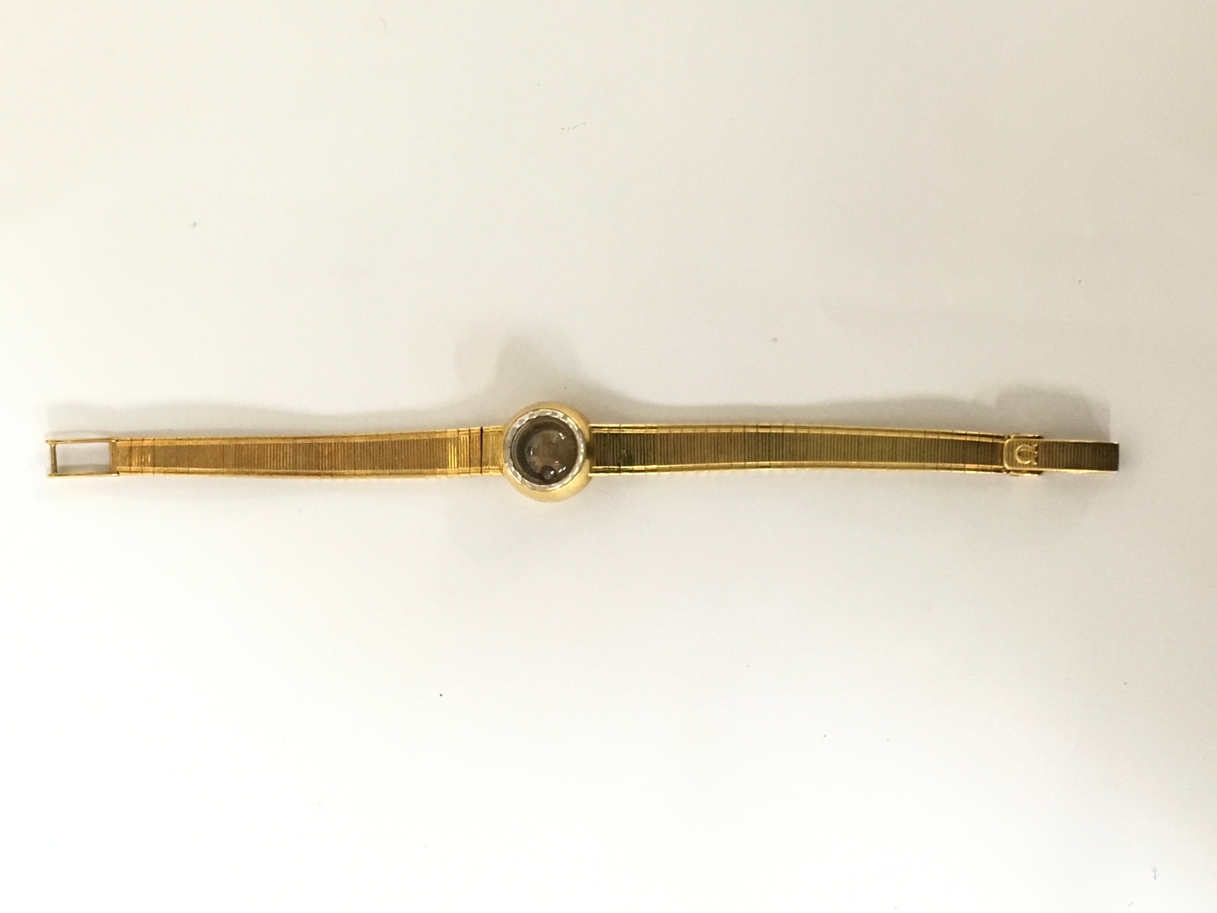 A lady's vintage Omega 18ct gold watch having small domed face on articulated strap.Approx: L6.5 x 1.5cm face cm 26g