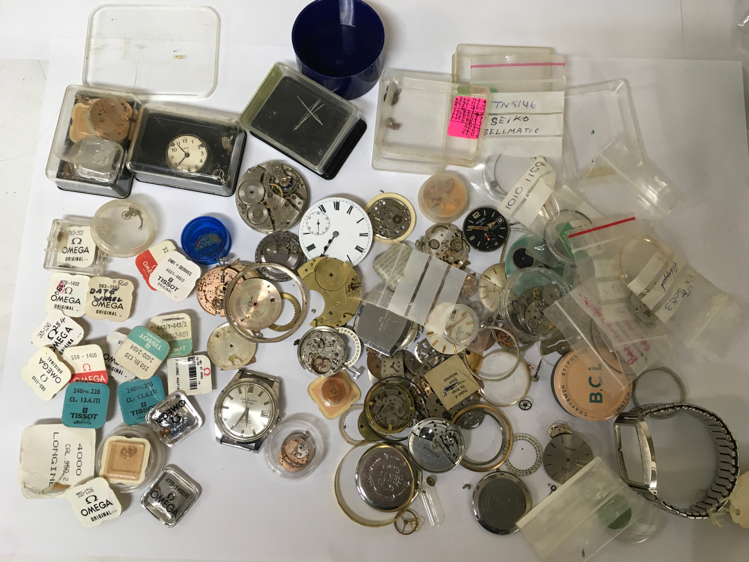 A bag of assorted watch parts including Omega