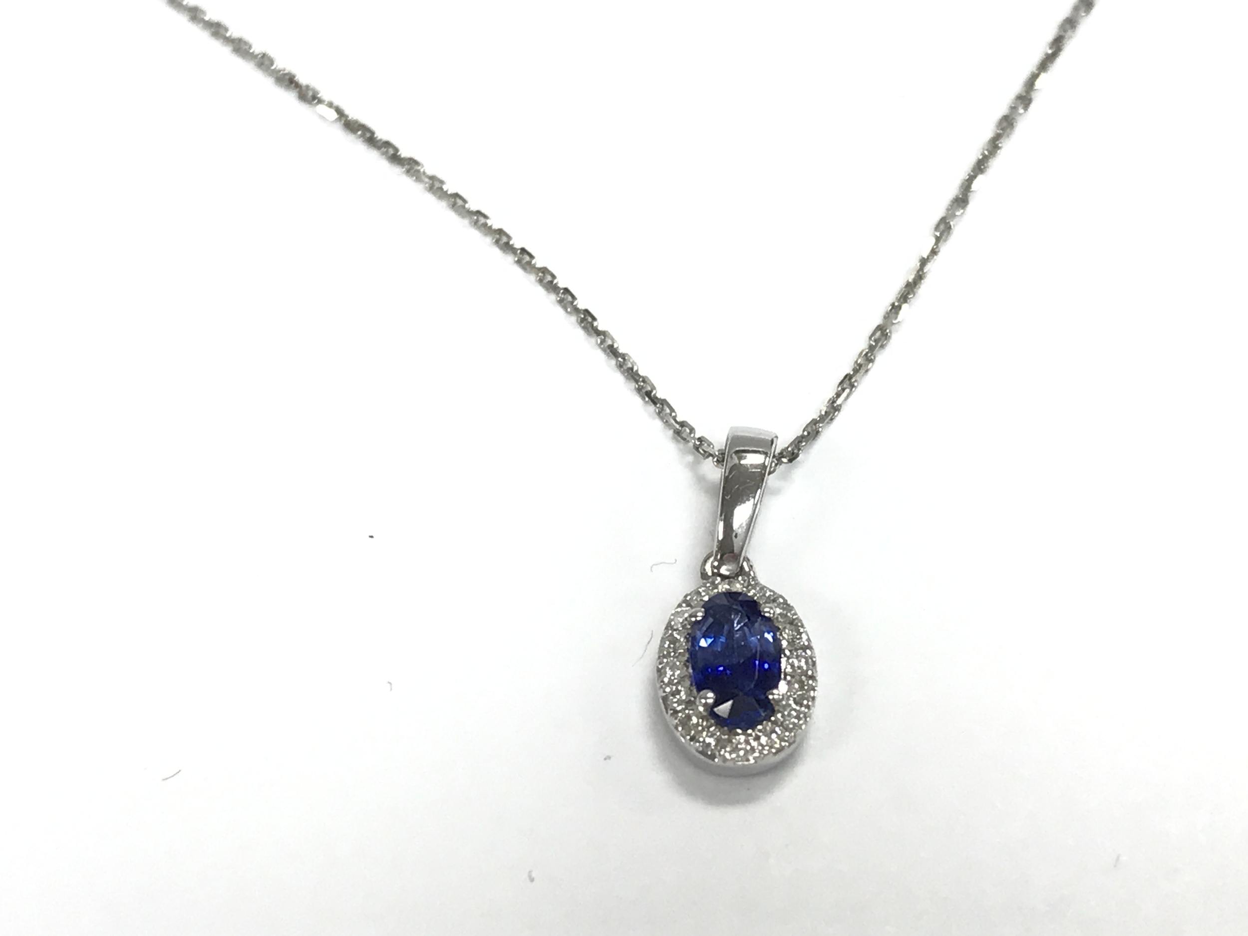 9ct white gold oval sapphire and diamond cluster pendant on a 9ct white gold chain. sapphire 0.37ct and diamonds 0.07ct.