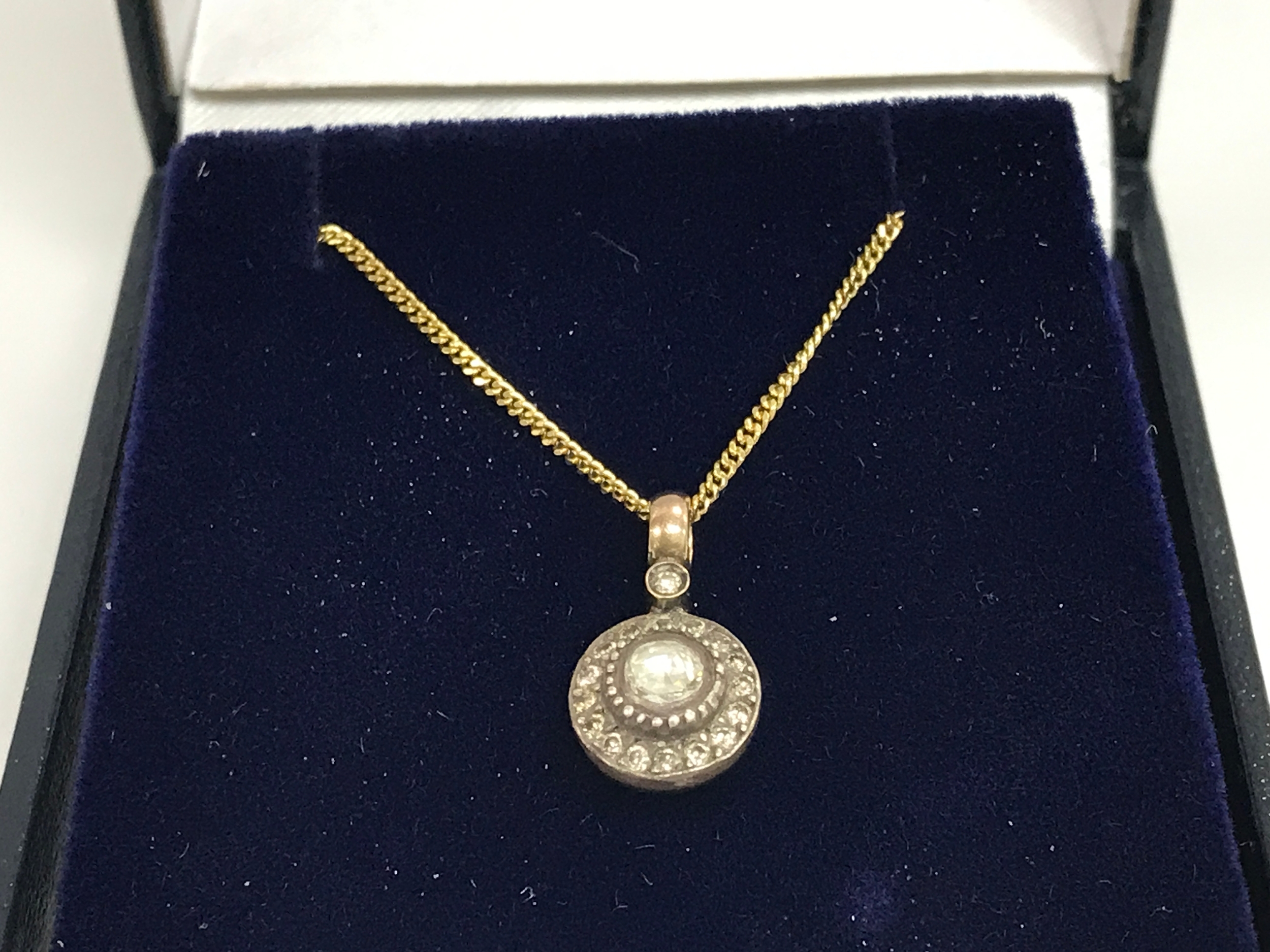 8ct (unmarked) silver topped diamond set pendant on a gold plated silver chain. Diamonds approx 0.35ct