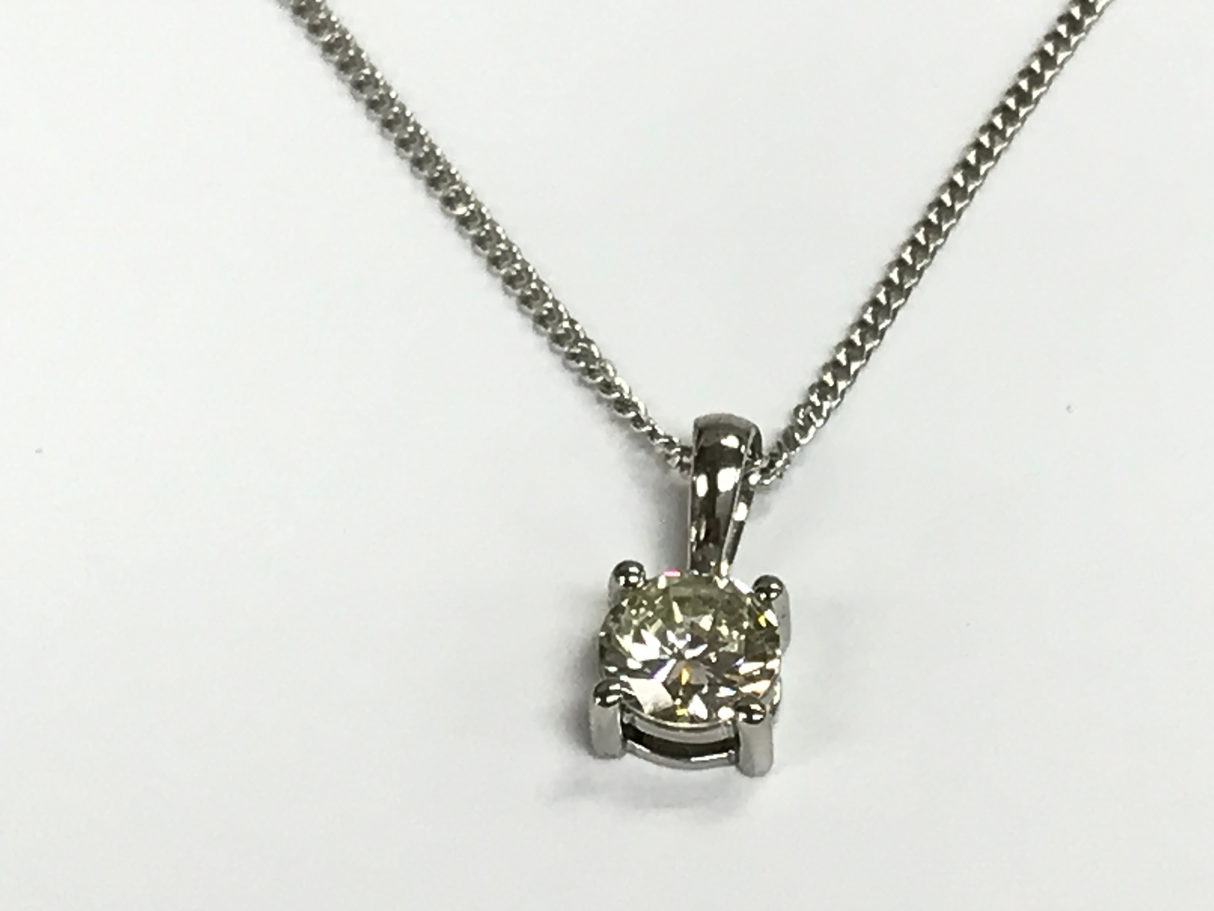 Platinum four claw set brilliant cut diamond solitaire pendant on silver chain. Diamond 0.45ct.