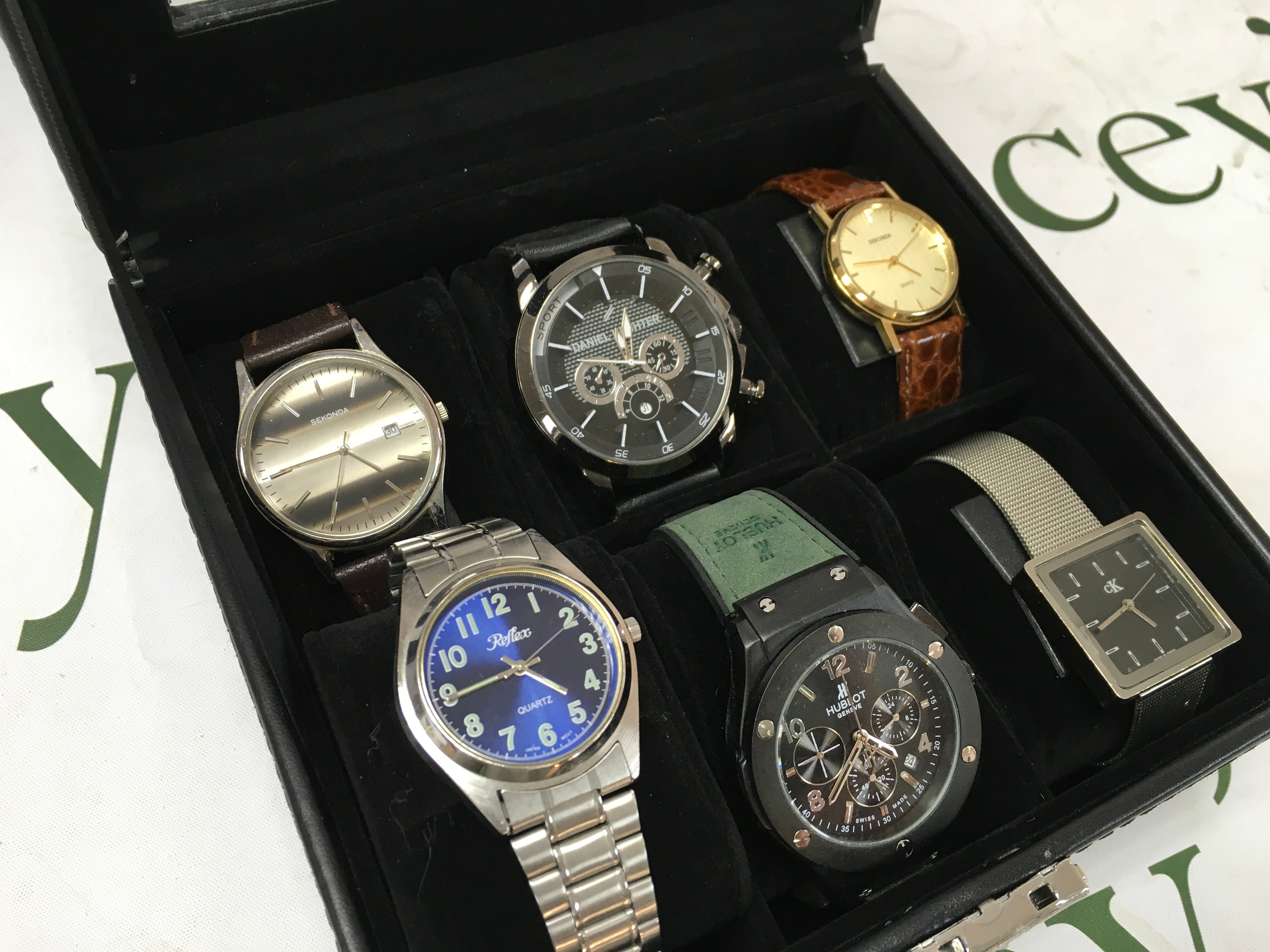 A collection of vintage gents watches, most seen working. In display case