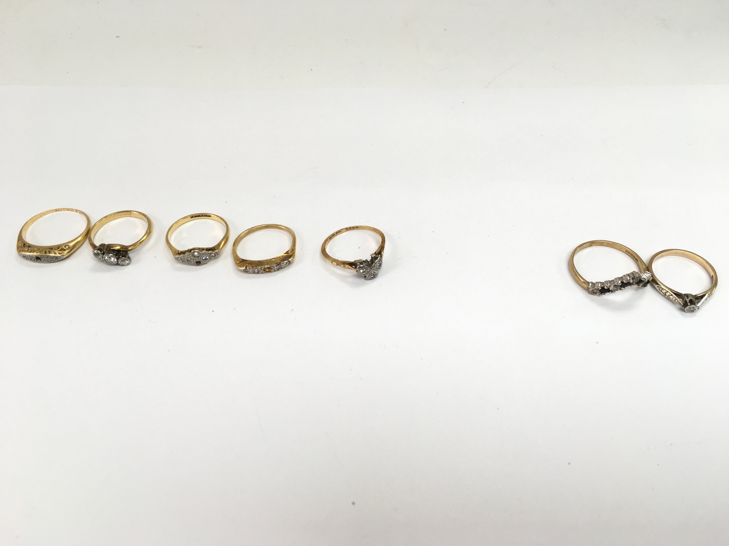 A collection of 7 stone set rings including 5 18ct gold 11.2g and two 9ct gold 4g