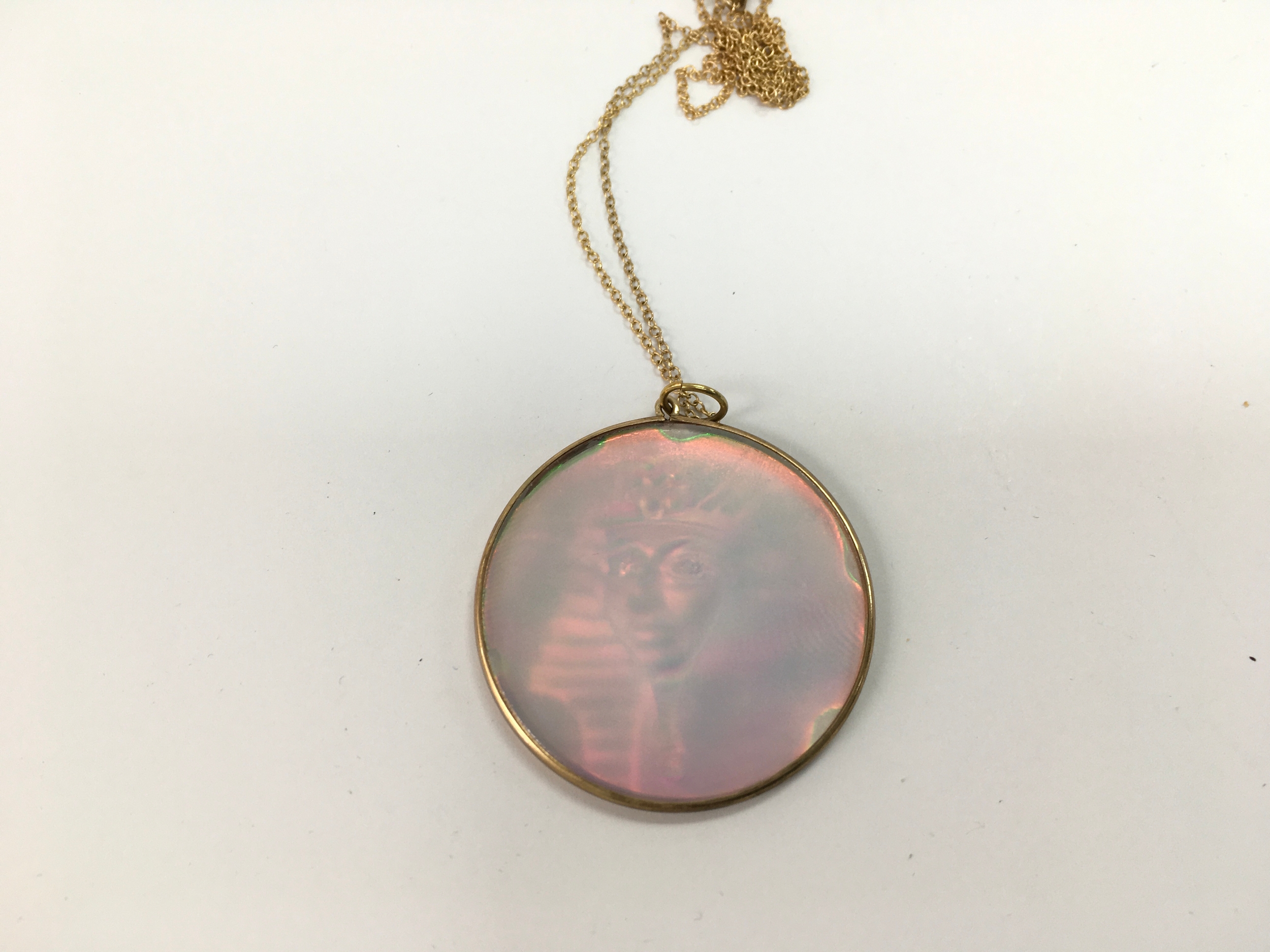 A 9ct gold hologram pendant on 9ct chain.