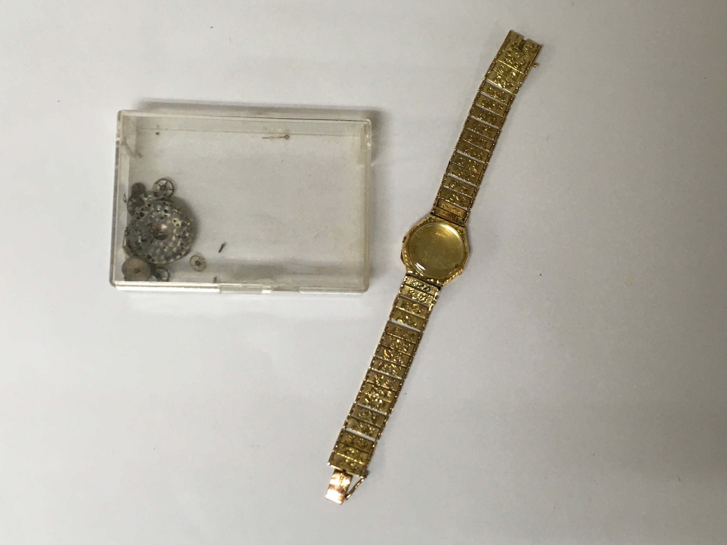 A 14k gold Doxa lady's wristwatch, having engraved articulated strap.Approx: W2 x L15.cm. Offered as spares or repairs, lacking movement. 13g