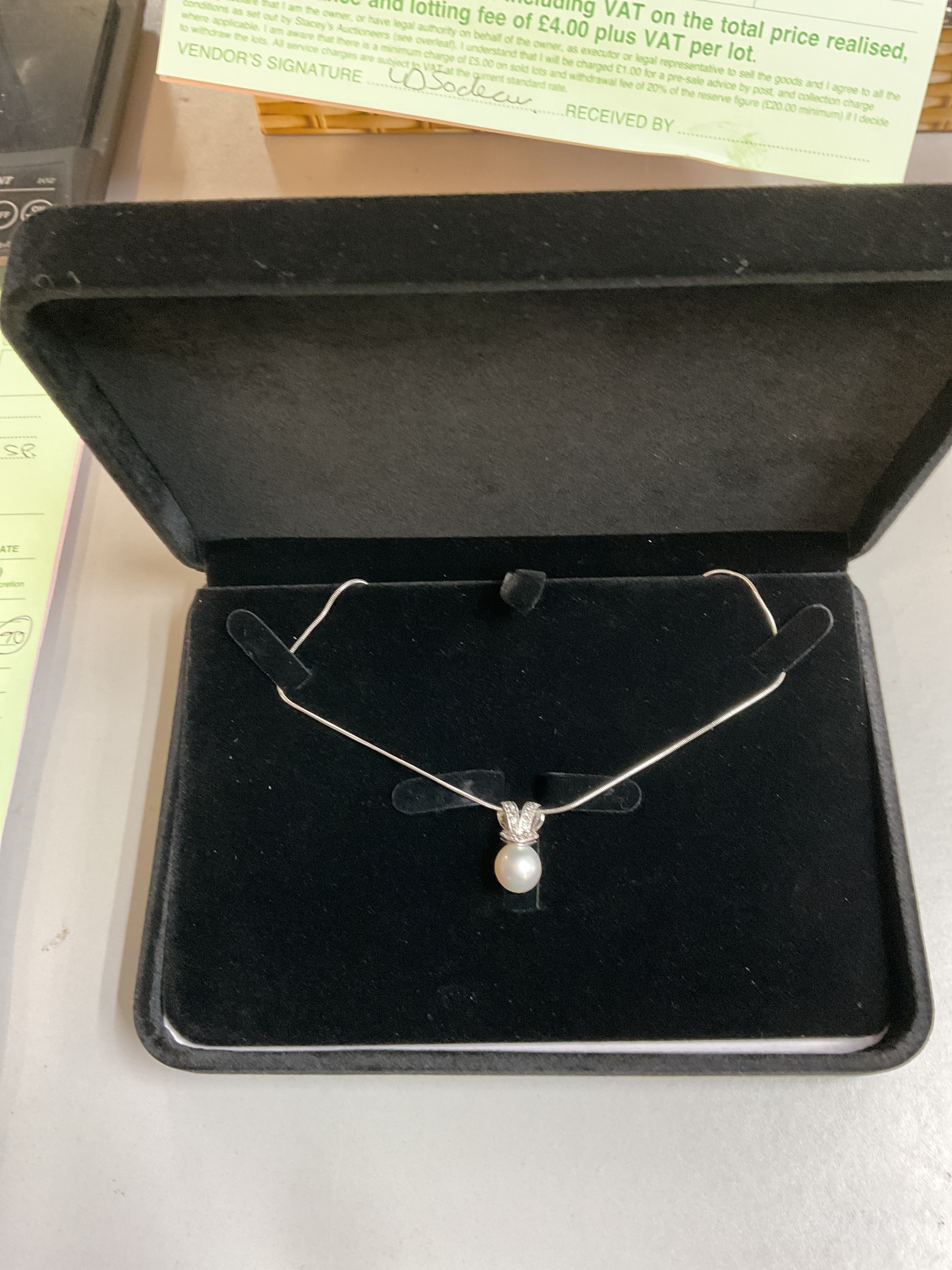 18 ct diamond set bow with a large south sea pearl suspended on a Platinum necklace.