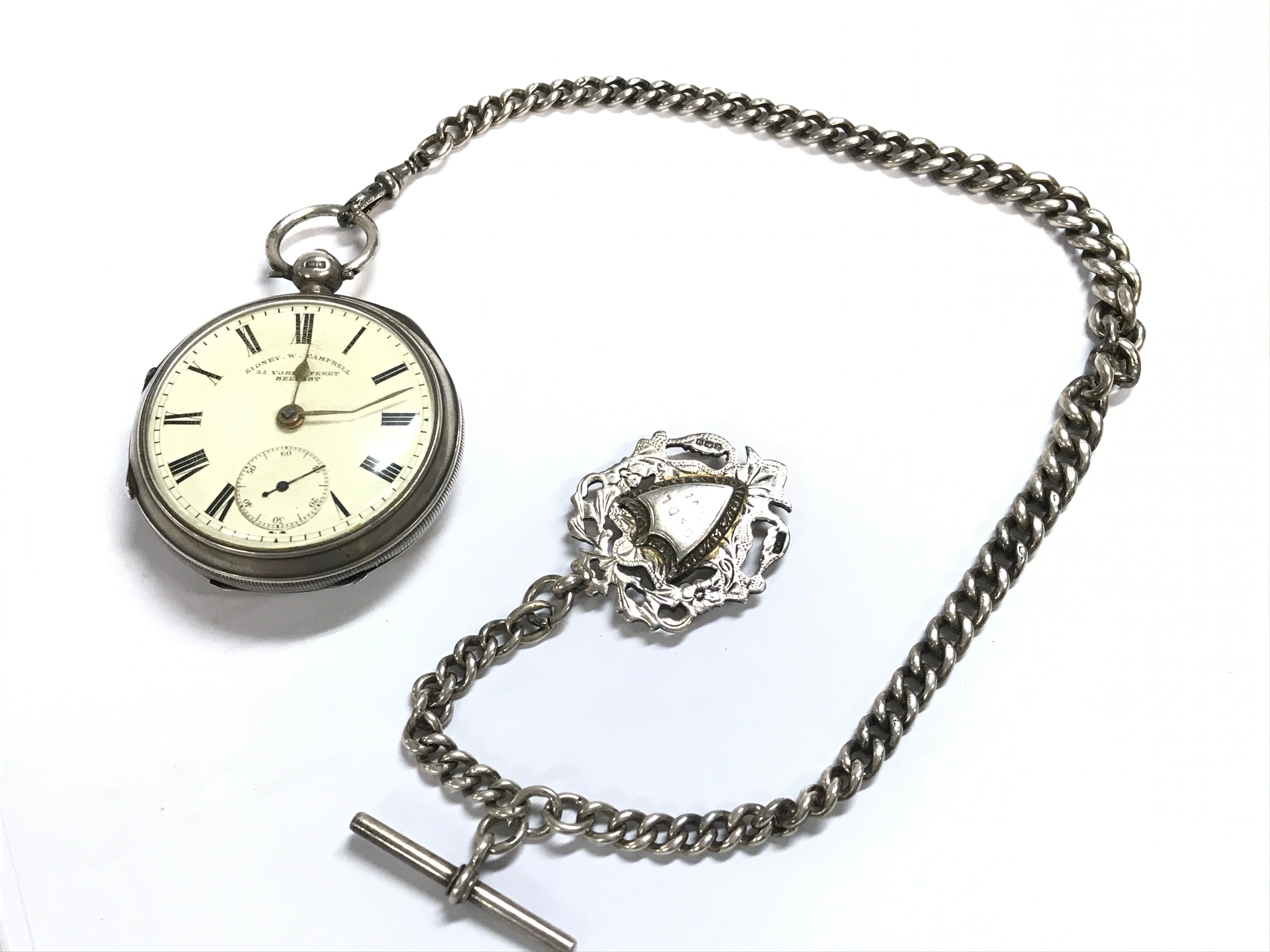 A silver hallmarked Sidney W. Campbell pocket watch with an Albert chain and fob . Chain 37cm long approximately. 185.7g total weight 
