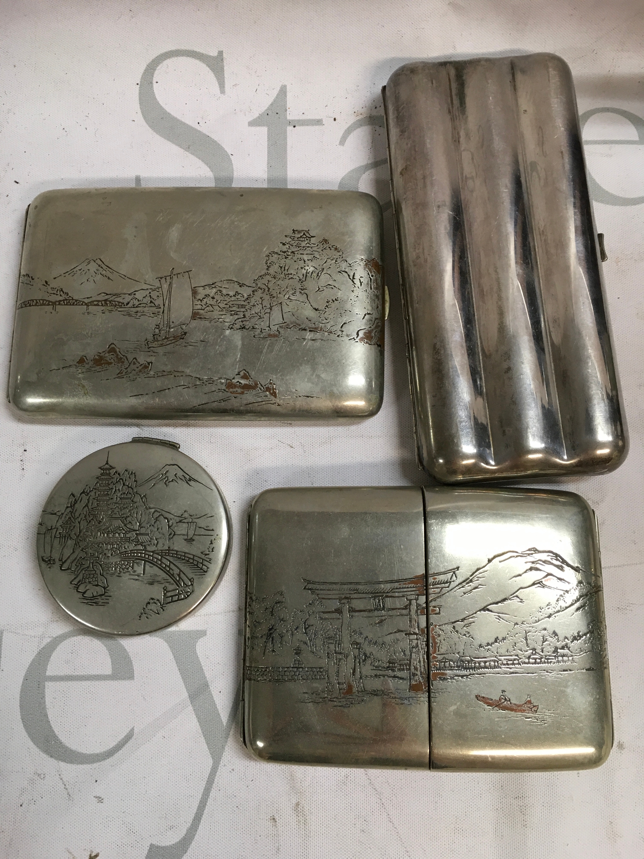 A collection of silver plated items including a cigar case and Japanese cases. 