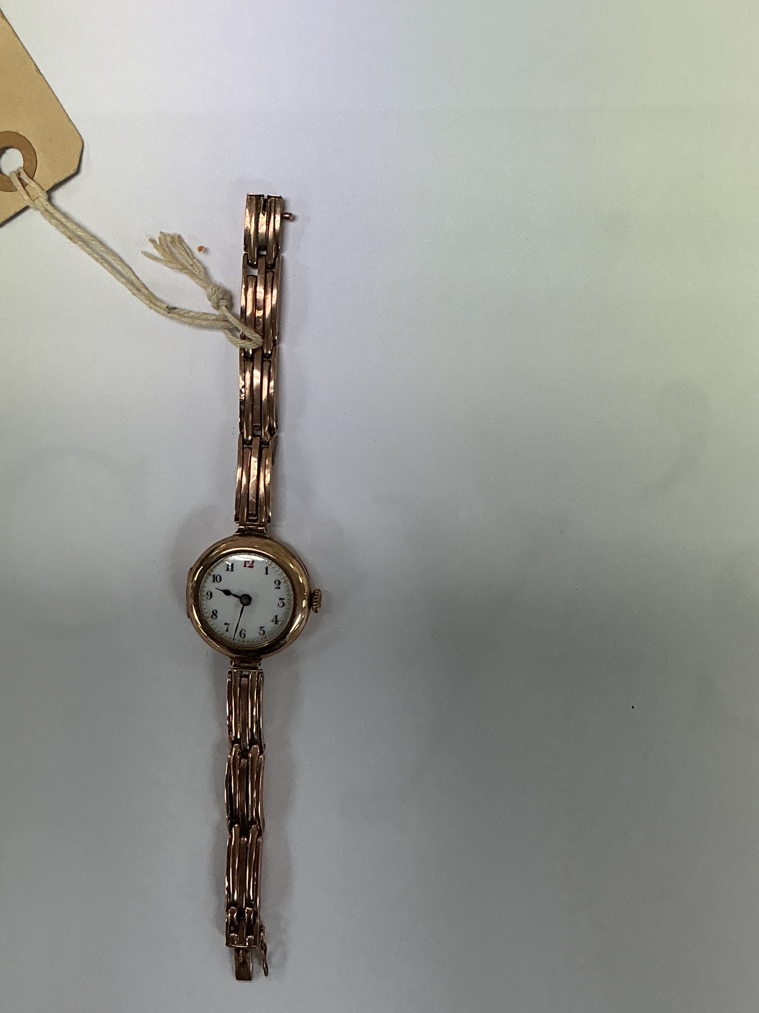 A vintage 9ct gold ladies wristwatch on articulated gold strap with enamel type face. Approx: 16 x 2.5cm face. 20.54g