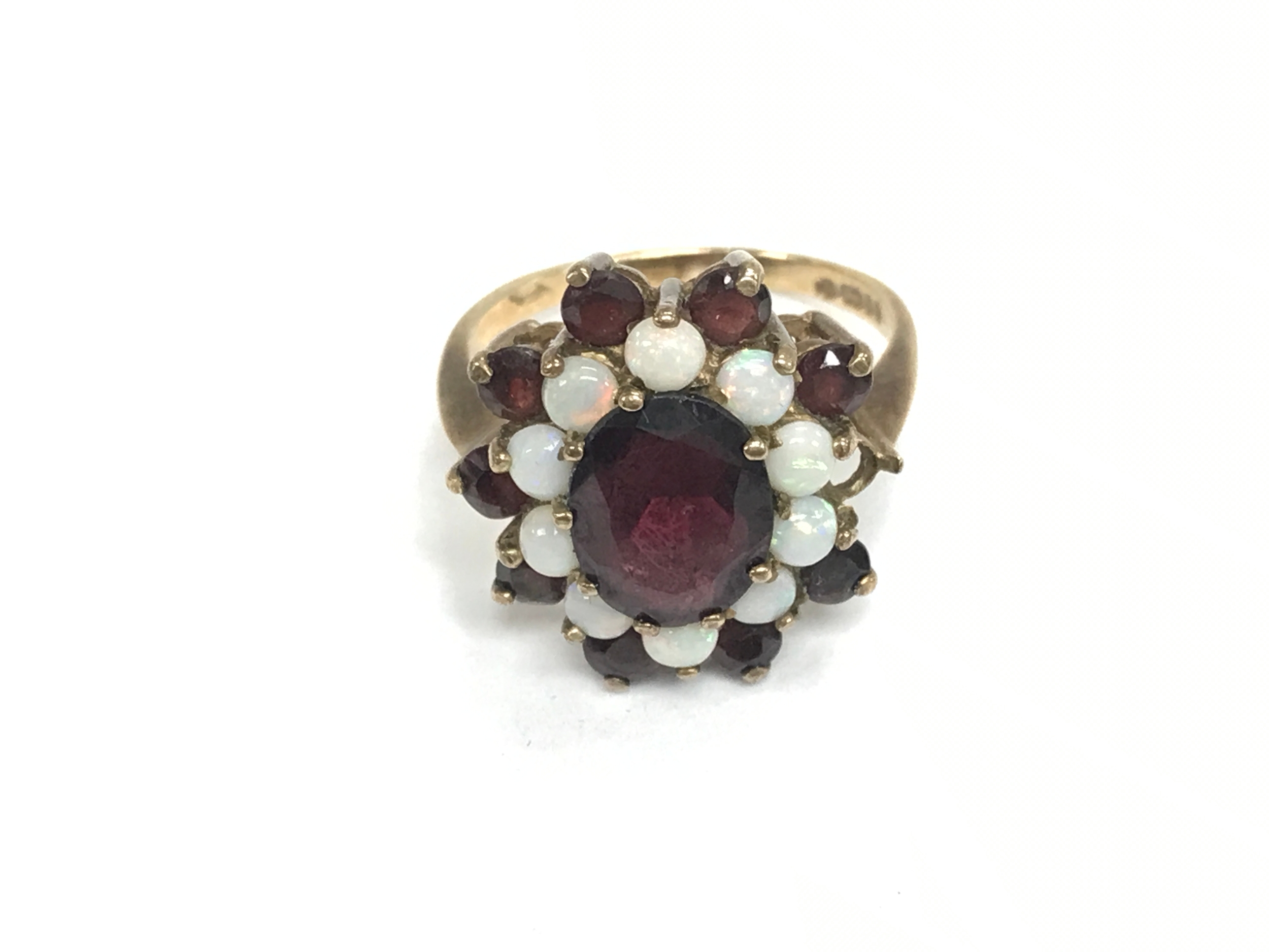 A 9ct gold ring set with garnets and Opal. Missing 1 stone, size P 1/2 and 4.4g