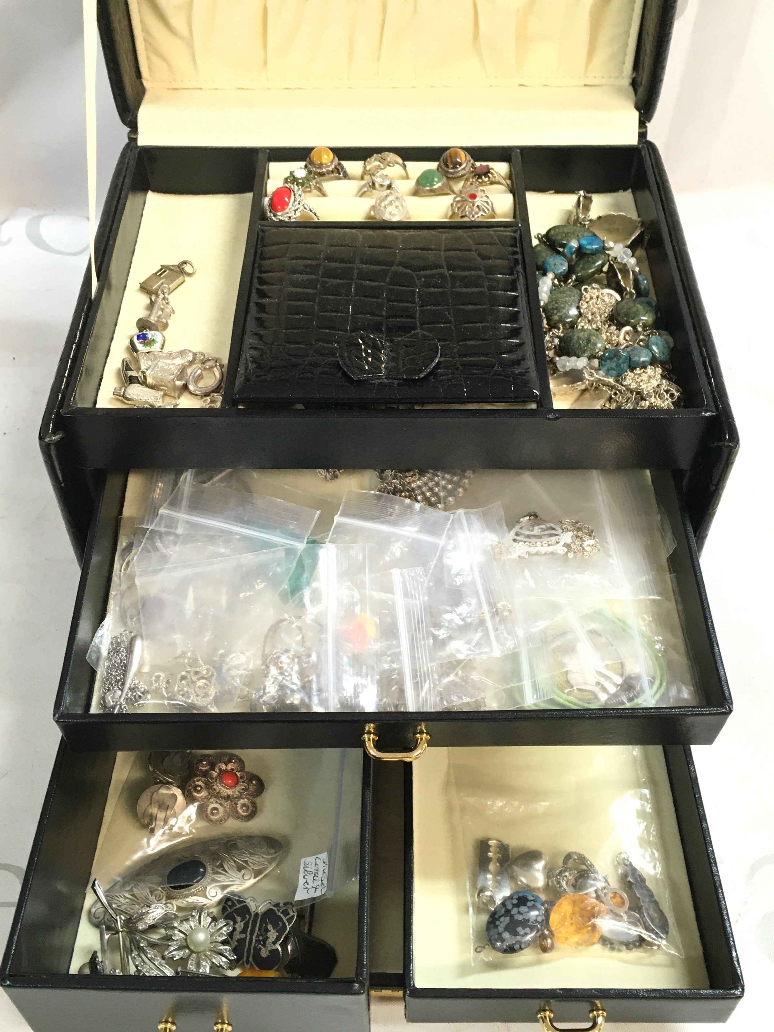 Black jewellery box including all silver 20 necklaces, 10 charms, 10 rings, 10 bracelets, 20 pairs of small earrings, 10 brooches, 10 pendants 