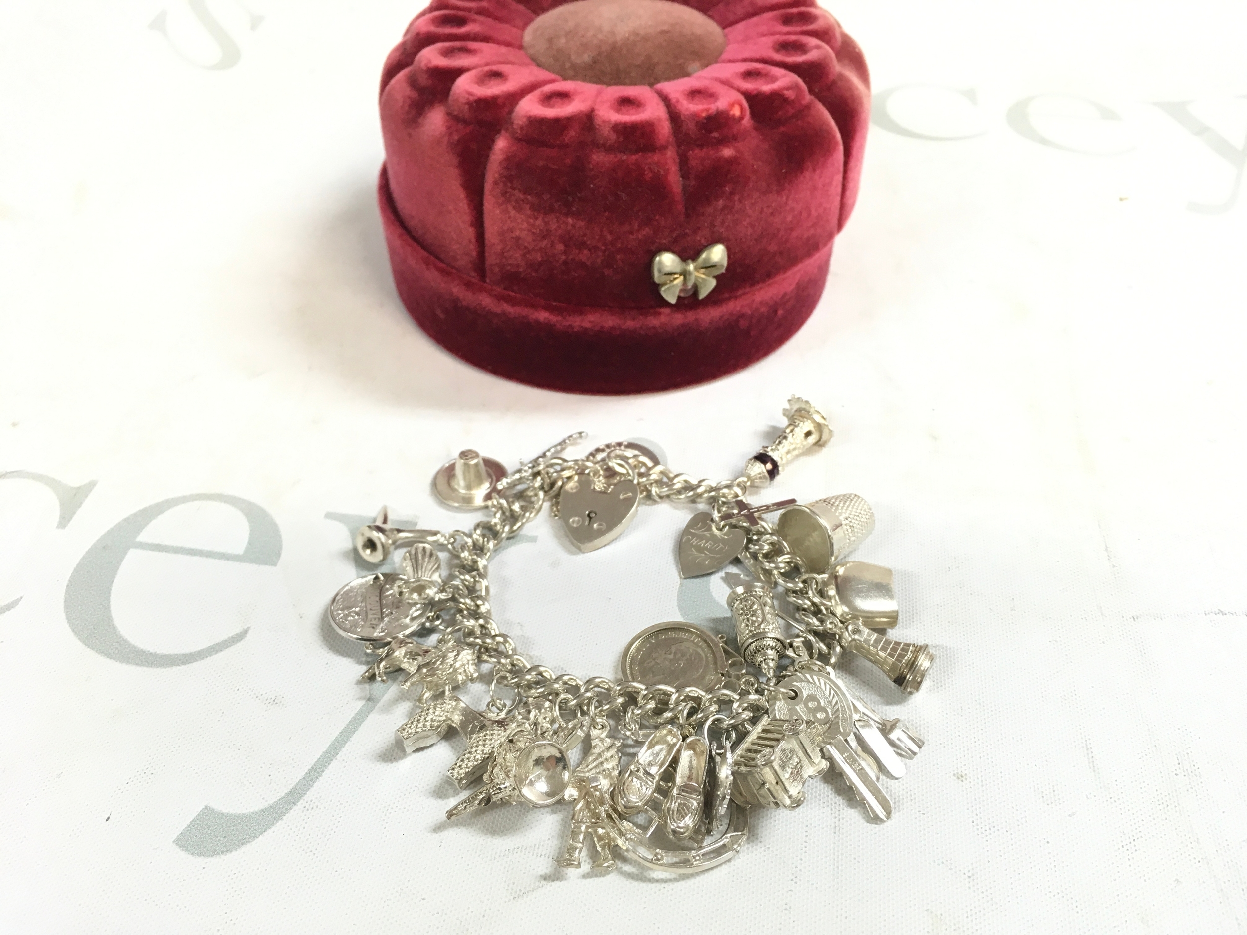 A silver charm bracelet (60s/70s/80s) 75grams. Approx 22 charms