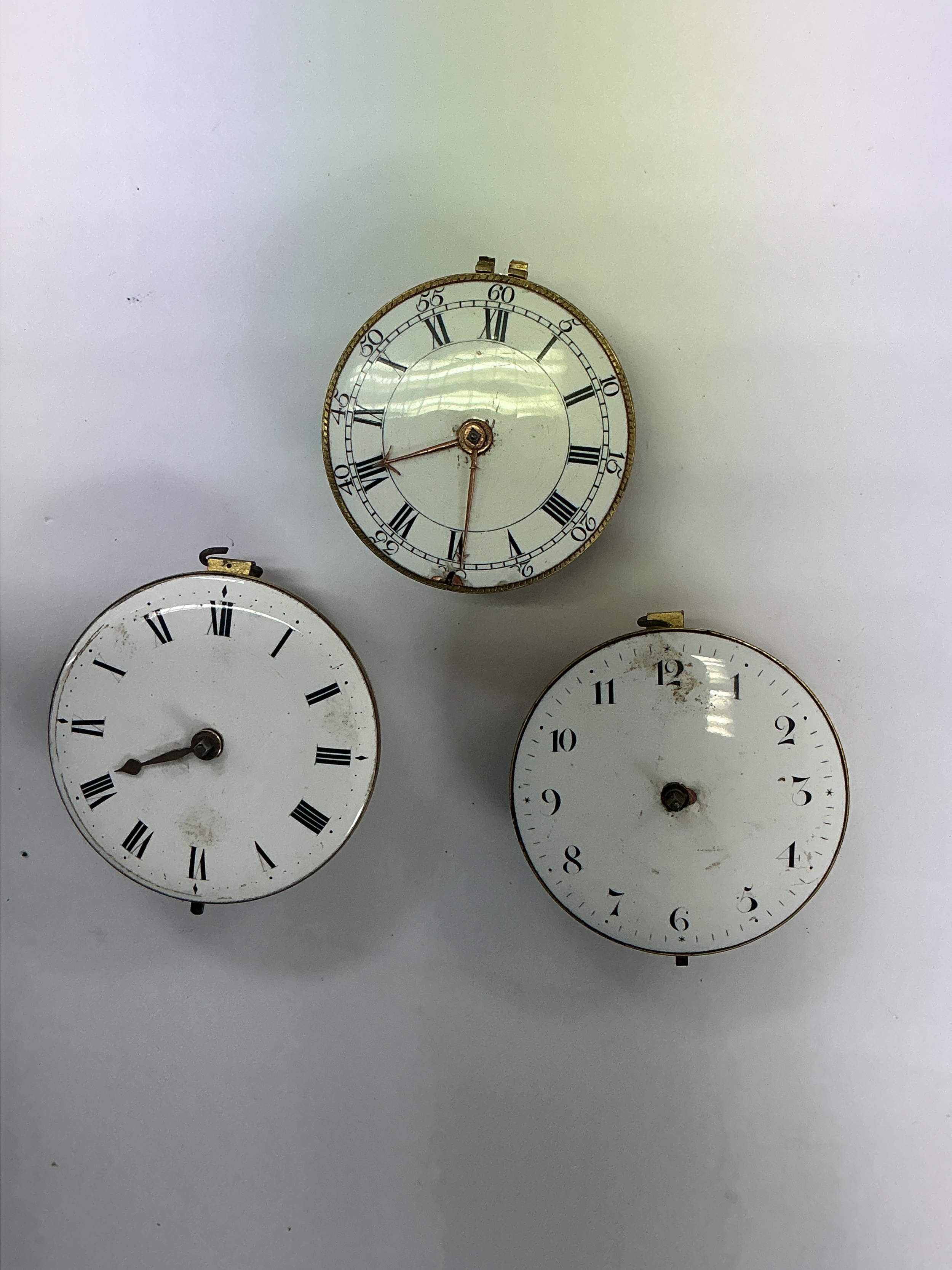 Three 18th century verge watch movements, all having enamel dials. Approx: 4-4.5cm respectively. Offered for spares or repair. 