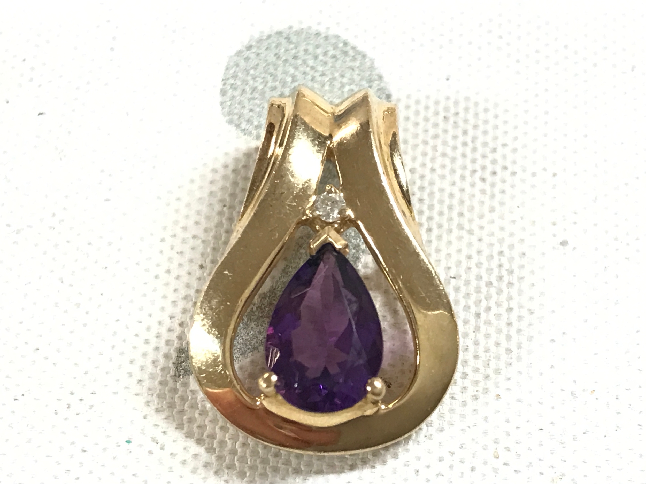 14ct gold pendant with amethyst coloured stone. 3.1g