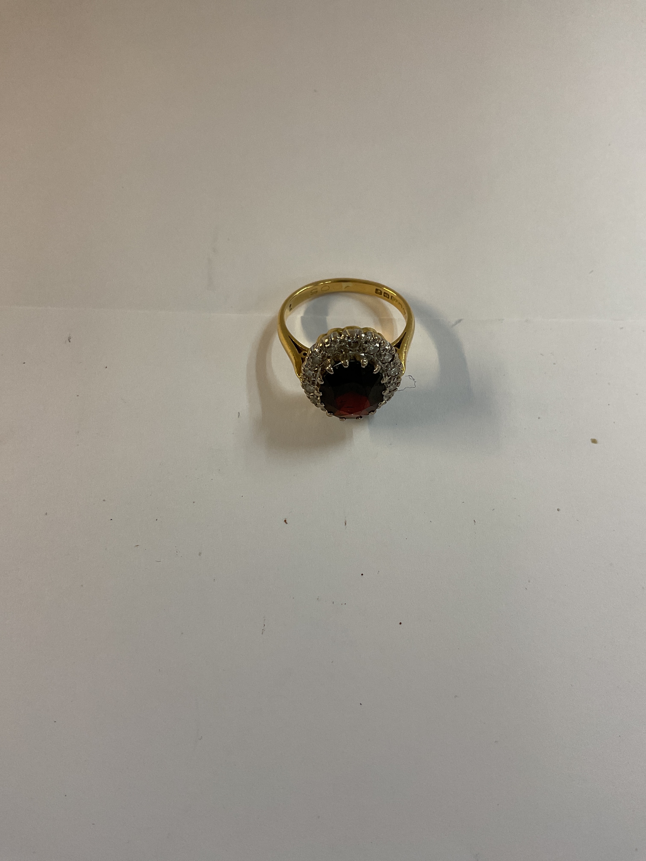 An 18 ct Diamond &  Garnet ring, with 15 (26 cuts) Diamonds around a Garnet measuring 11.5 x 8.5 x 4.5 mm hallmarked 18 ct, Birmingham 1970, size K weight 5.2grams.